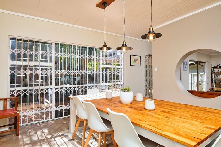 A sunny dining room with a wooden table, ready for a tenant
