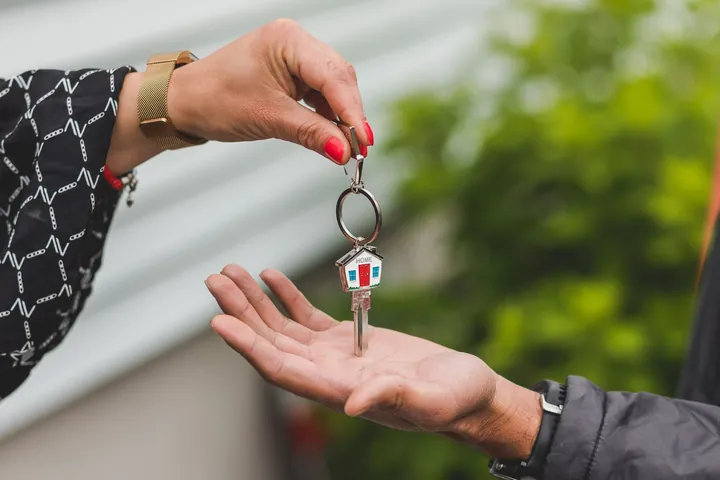 A house key being handed over